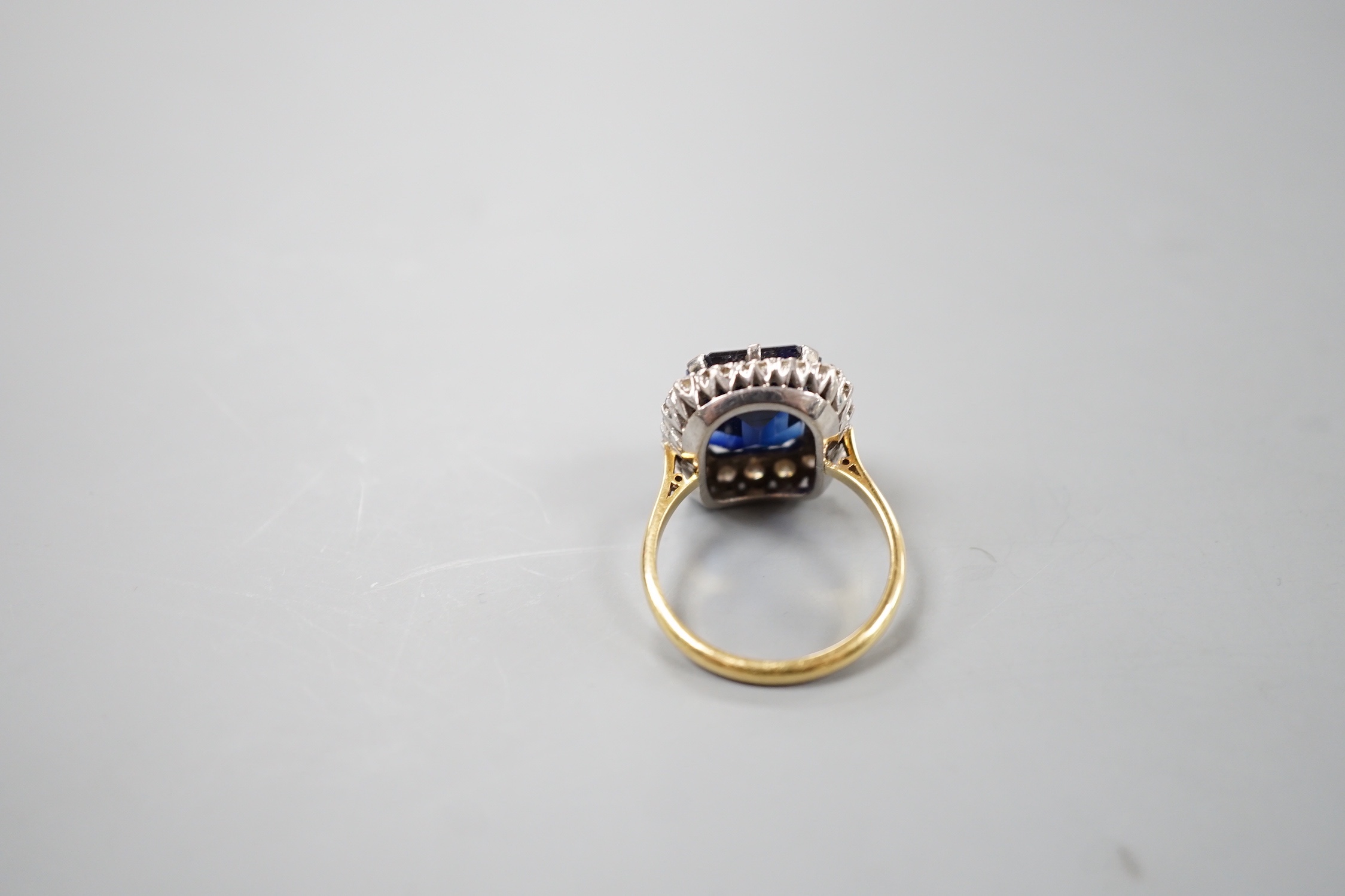 An 18ct, synthetic sapphire and diamond set rectangular cluster dress ring, size T/U, gross weight 10 grams.